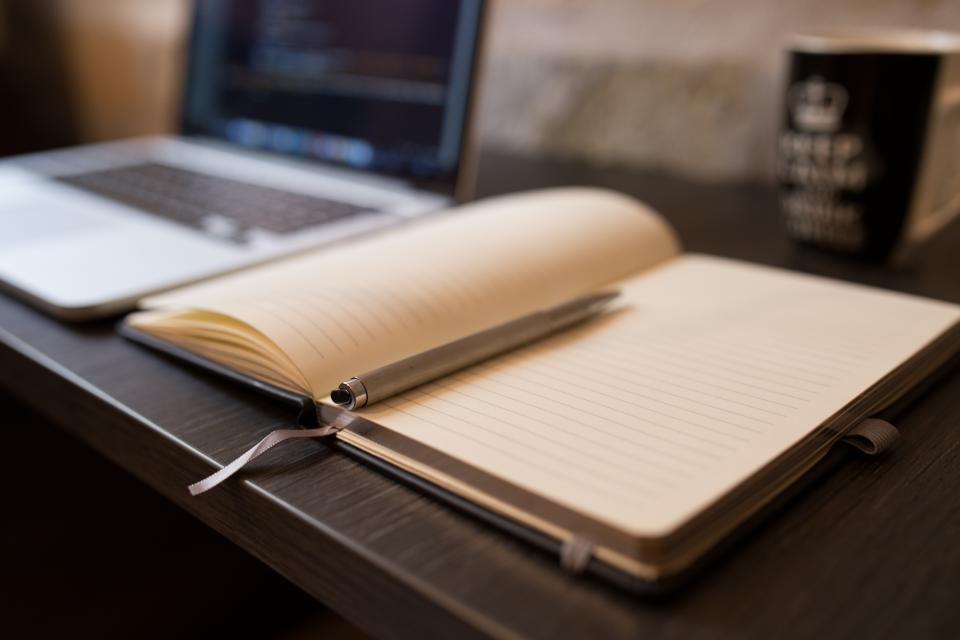 Carnet et stylo pour préparer un script de prospection téléphonique B2B